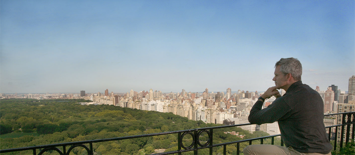 Man overlooking central park from his Hampshire House balcony.